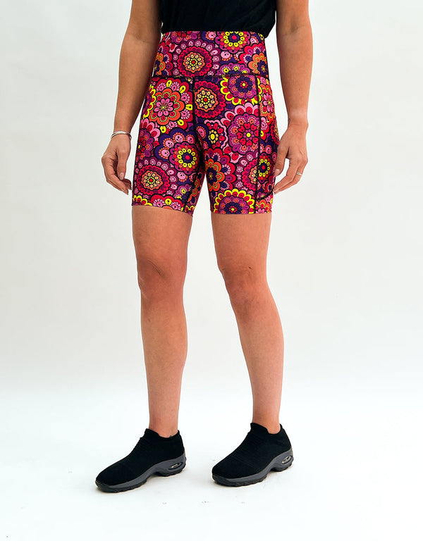 Women wearing vibrant retro floral running shorts with deep side pockets and elastic waistband