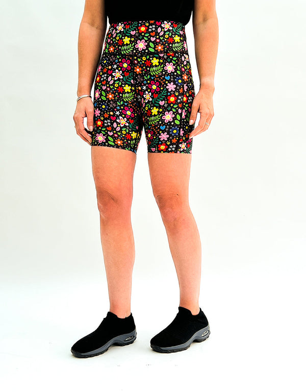 Women's running shorts with vibrant floral festival print and side pockets, designed for comfort and activewear.
