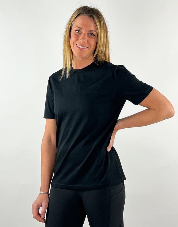 Woman wearing a black casual llama t-shirt made from 100% organic cotton with a unisex fit and embroidered logo.