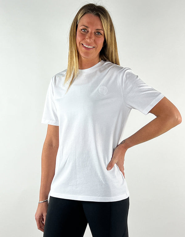 Woman wearing white casual llama t-shirt made from 100% organic cotton with embroidered logo and unisex fit