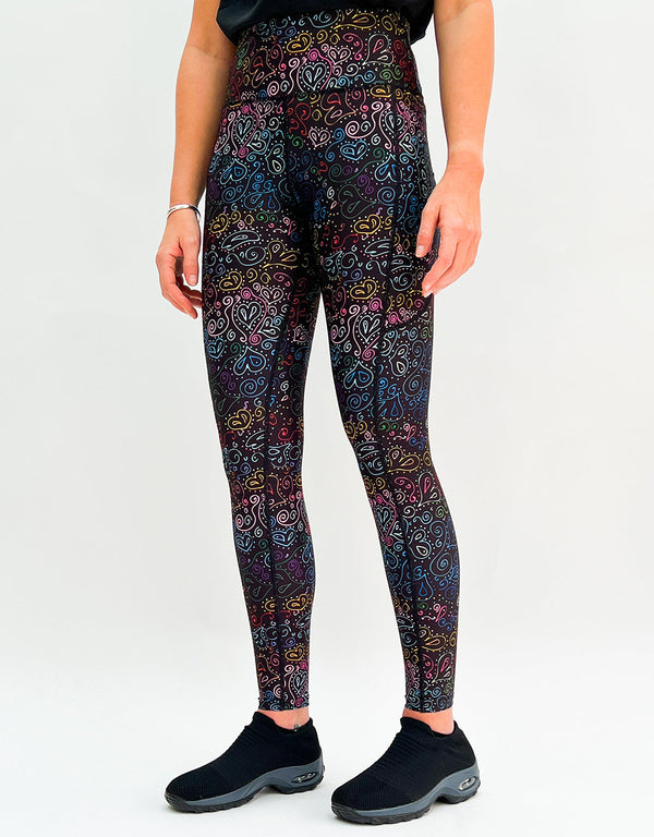 Female wearing Doodles Of Love activewear leggings with multi-colored heart doodle patterns and pockets.