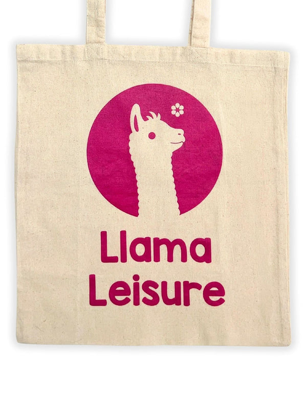 Beige tote bag with pink llama graphic and text "Llama Leisure" printed on front